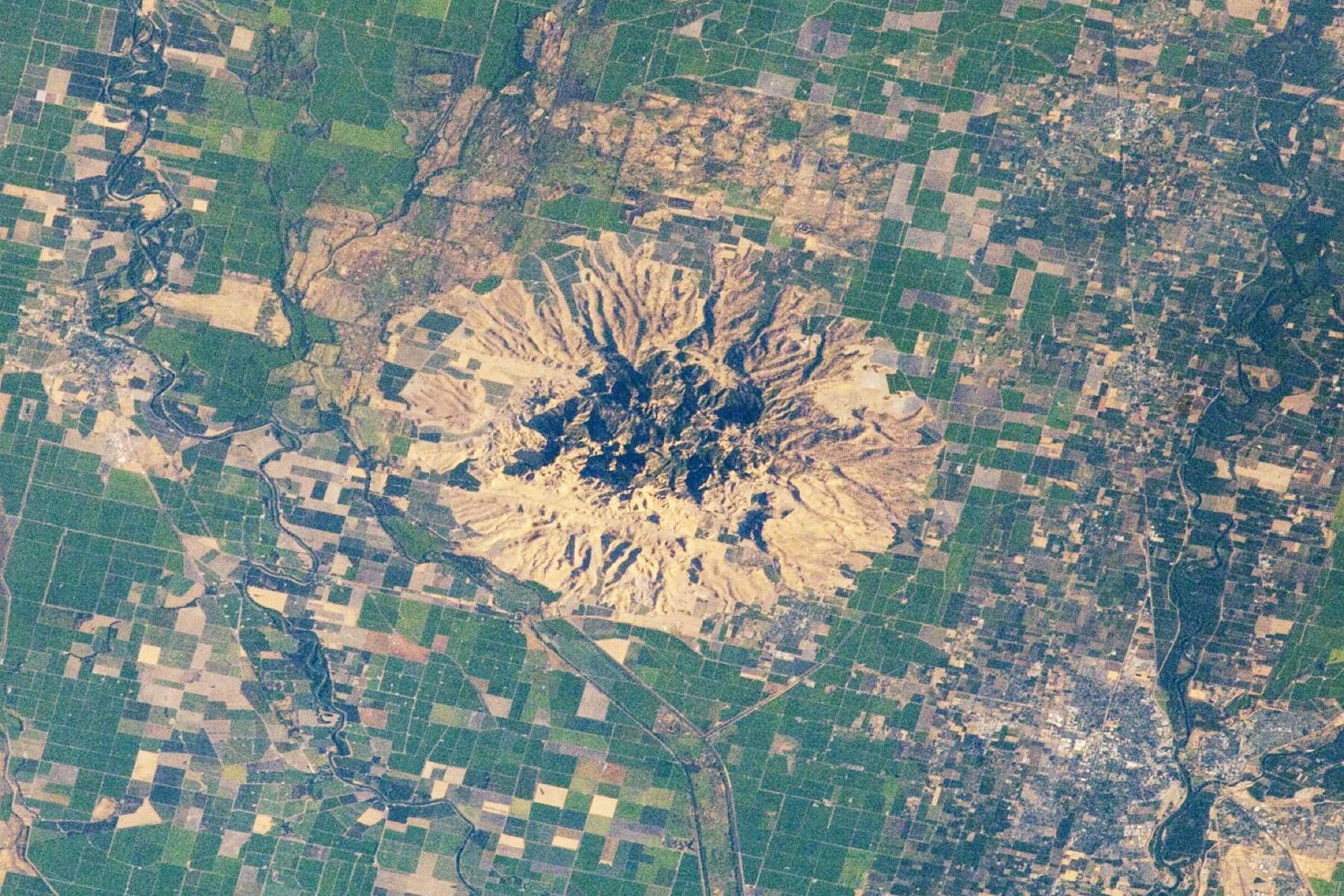 Sometimes called the “smallest mountain range in the world,” the Sutter Buttes rise almost 610 meters (2,000 feet) above the flat agricultural fields of the Great Valley of central