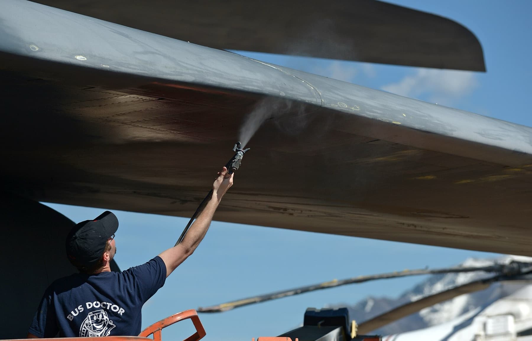 A fresh coat of gunship gray paint is sprayed onto the underside of the leading edge on the wing of the Rockwell B-1B Lancer nicknamed "7 Wishes," (S/N 83-0070), at the Hill Aerosp