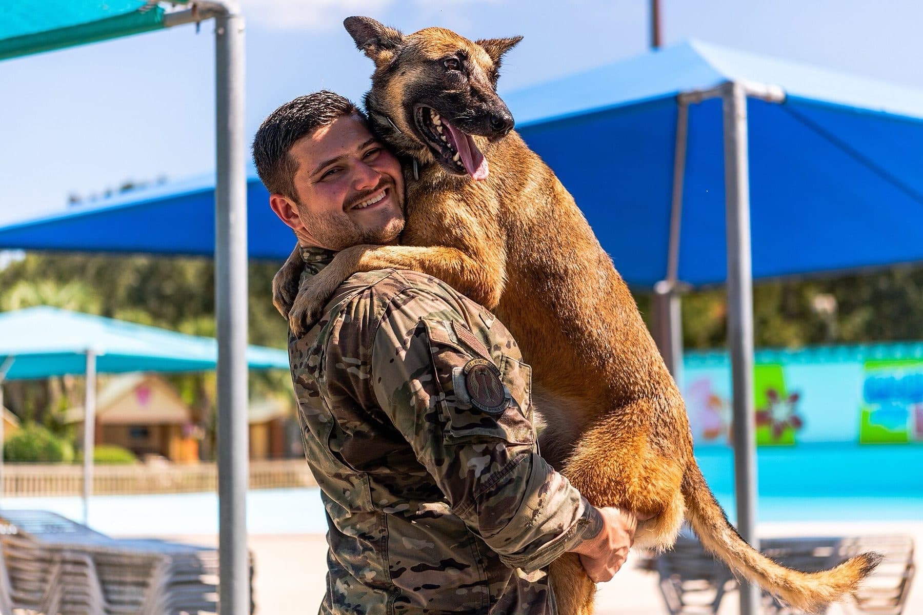 A military working dog and its handler from the 820th Base Defense Group, 93rd Air Ground Operations Wing, pose for a photo at Wild Adventures Theme Park in Valdosta, Ga., Sept